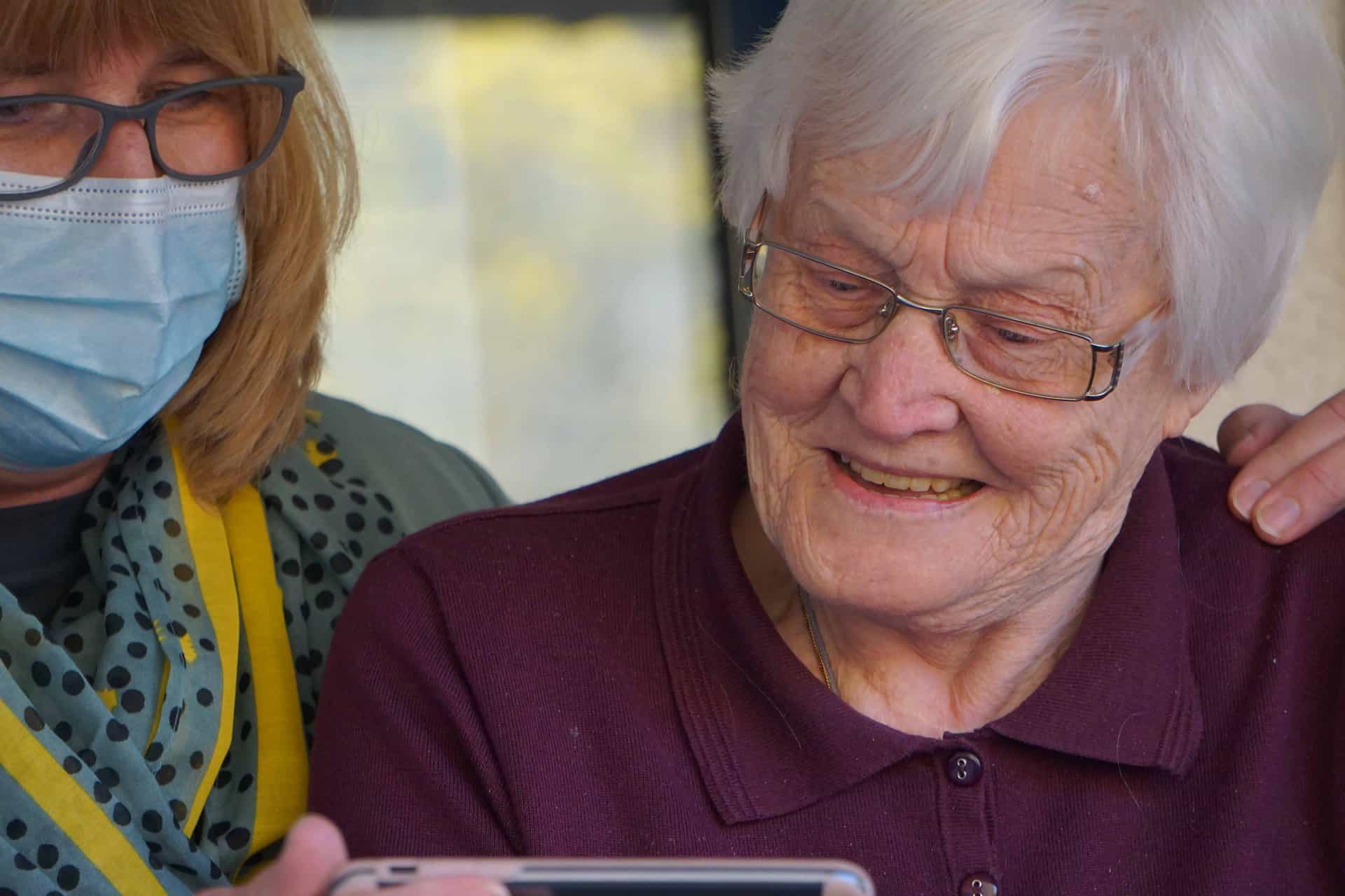 A care worker showing a video to an elderly person in a care home